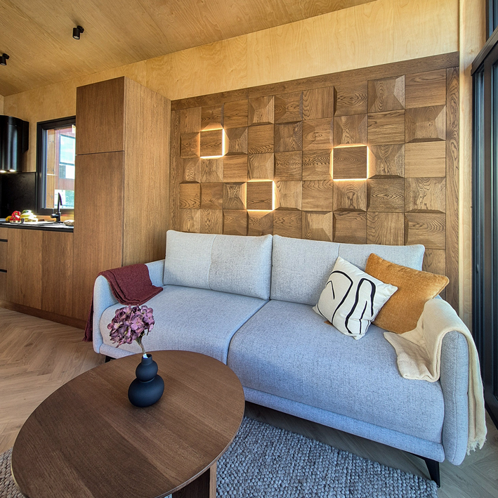 Phòng khách hiện đại với tấm gỗ ốp tường 3D trang trí tông tự nhiên phía sau ghế sofa