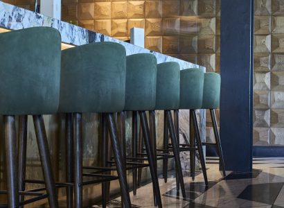 3D wooden wall panels in a modern restaurant interior with blue bar stools