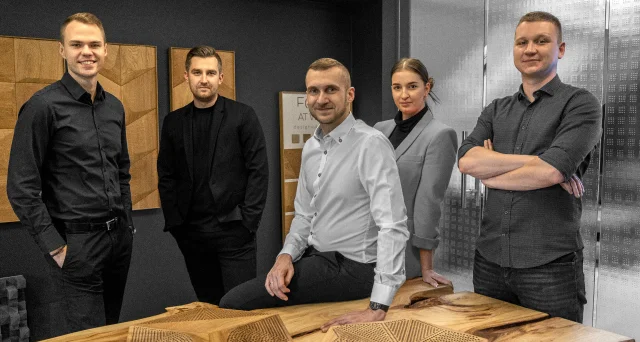 The design team in the 3D oak panels manufacturer's showroom, presenting modern wall solutions and solid wood furniture.