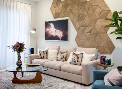 Cozy living room with a geometric rustic wood accent wall above a beige sofa, adding warmth and texture to the space