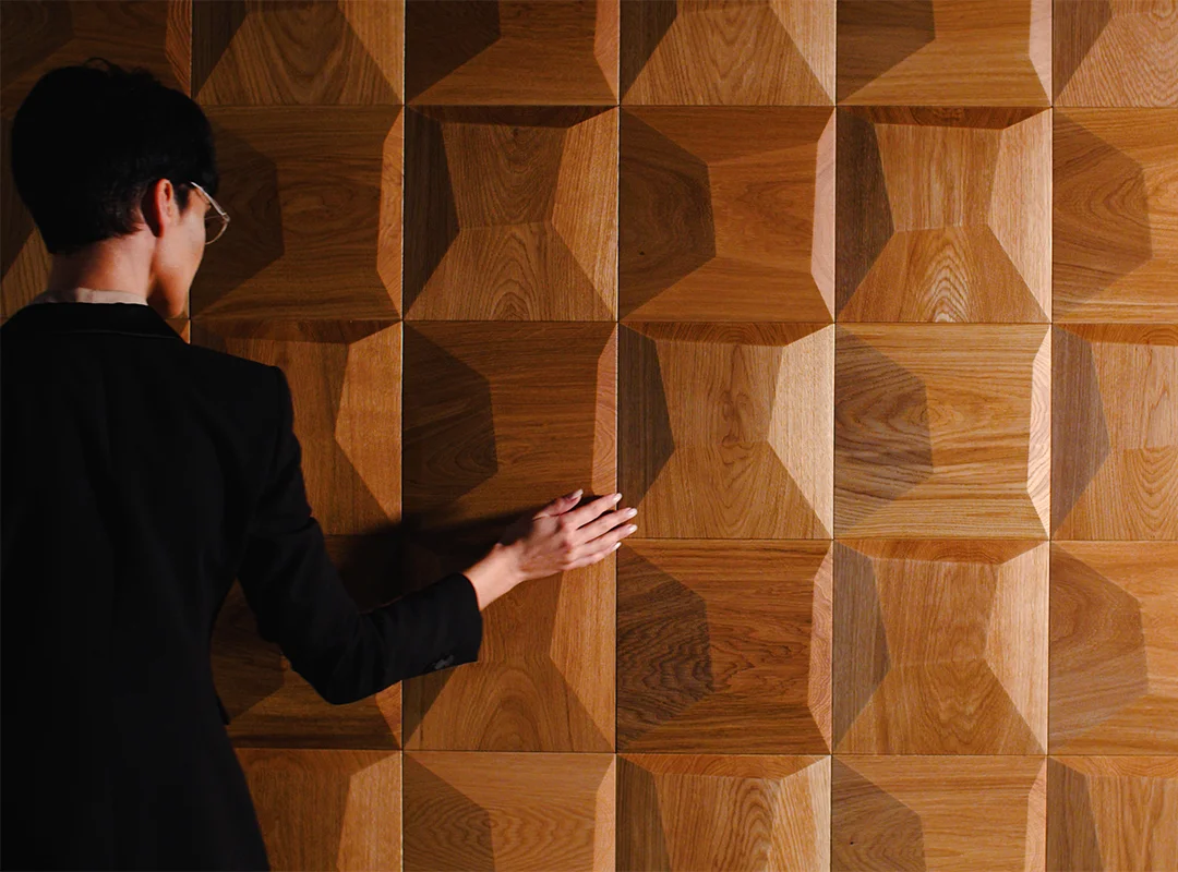 Close-up of textured decorative wood wall panels being touched by hand
