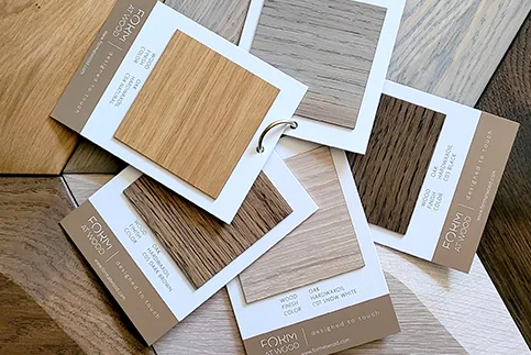 Various wood panel samples with finish labels on a table